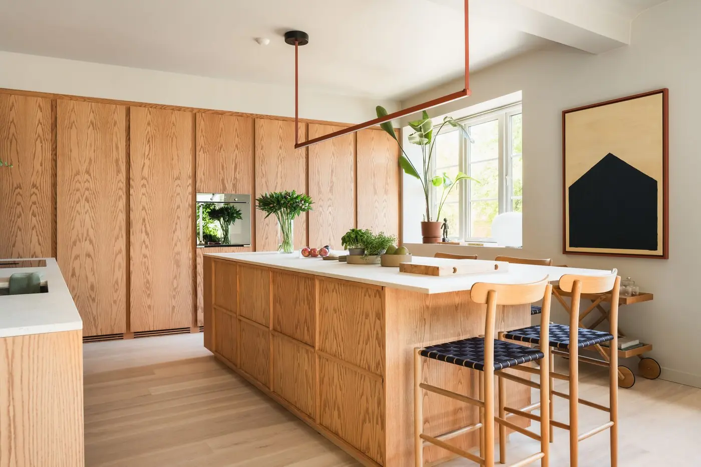 En stor kjøkkenøy med Dekton-benkeplate gir rikelig med både arbeidsflate og sosialt samlingspunkt.