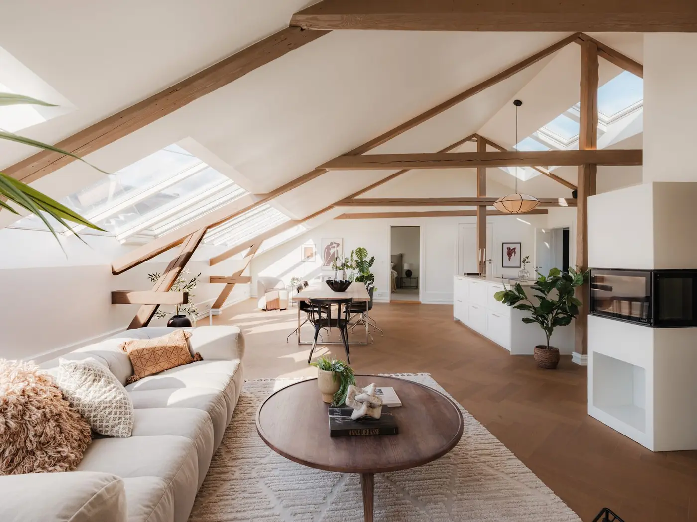 Gjennomgående loftsleilighet med hele 3,85 meter under mønet, synlige trebjelker og ildsted med glassdører.